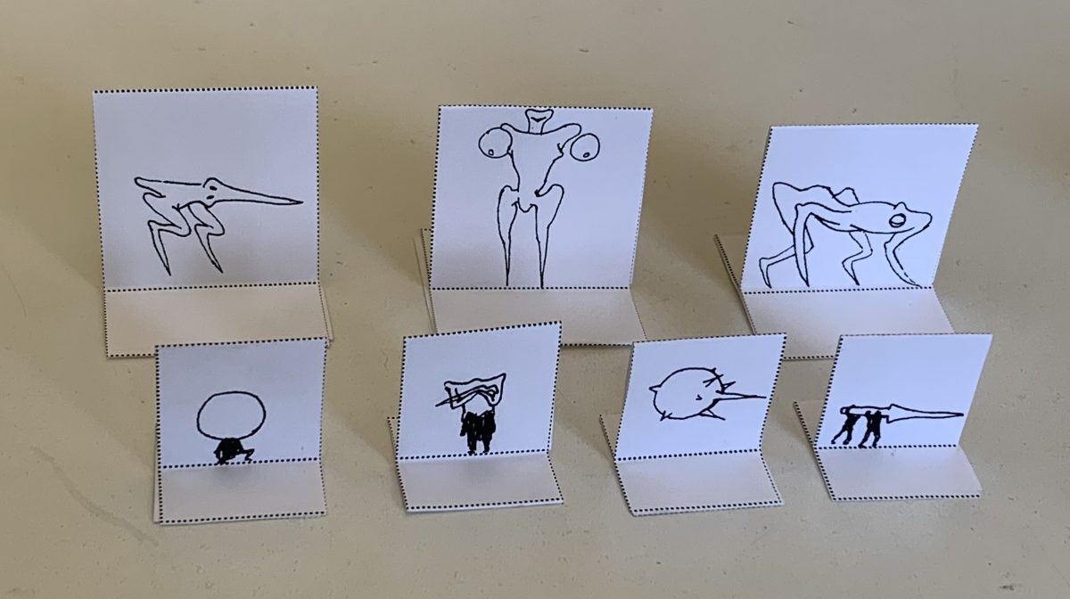 7 Paper standees with pen drawings surreal aliens.