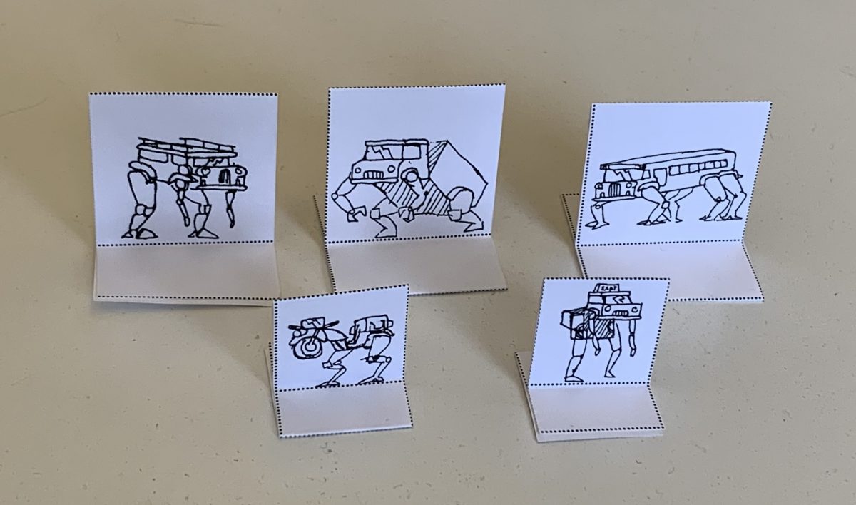 Five Paper standees with pen drawings of transformed vehicle mechs.
